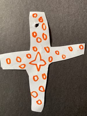 Child's drawing of a swiss cross covered in stars